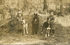 Clara and Bessie Jensen with stuffed bear and prized hunting dogs