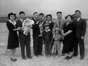 Left to right are, Mr. and Mrs. Howard Sakura and their baby, Frederick Scott Sakura, 10 weeks old; Chester is holding Jr., age 2; John David, age 7, is standing in front of Mrs. Chester Sakura; Gerald, 3-1/2, is in front of Kenny; Mrs. Misa Sakura, mother of the Sakura brothers; and Ted.  All the children, except the baby, belong to Chester. 